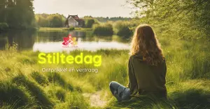 Vrouw zit in gras aan een meer